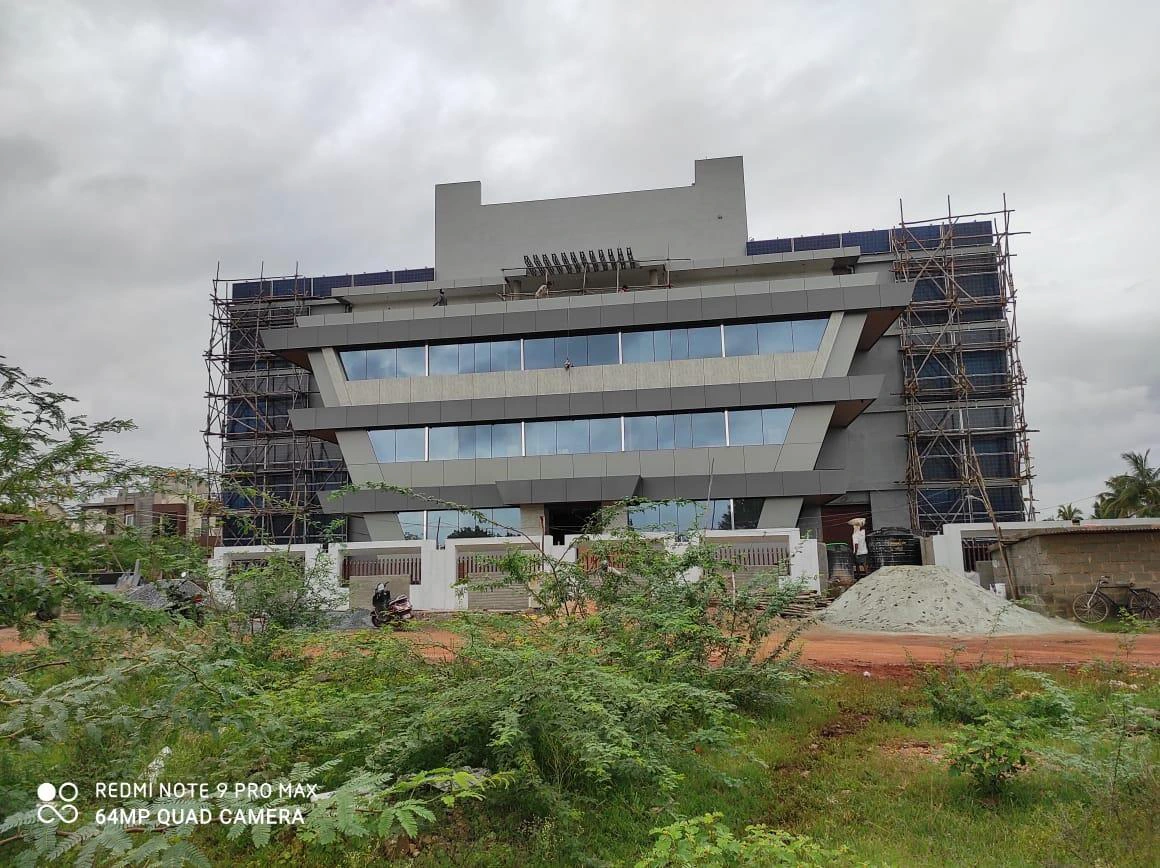 Commercial building under construction with wall-mounted solar panels across the facade