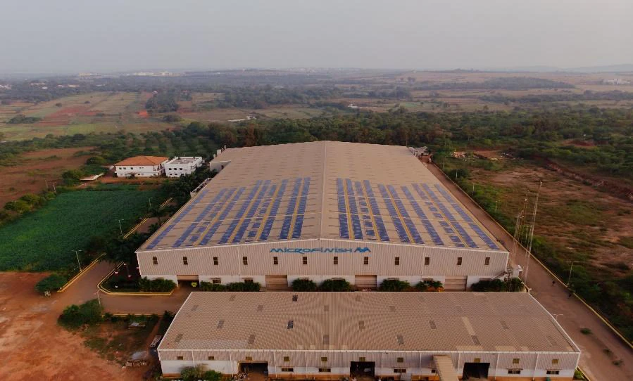 Rows of solar panels on an industrial rooftop at Microfinish